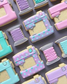 many decorated cookies are arranged in the shape of sewing machines and buttons, with pastel colors on them