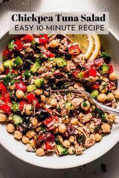 chickpea tuna salad in a white bowl with a fork and lemon wedge on the side