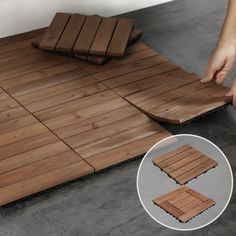 a person is placing wooden floor tiles on the ground to lay them on top of each other