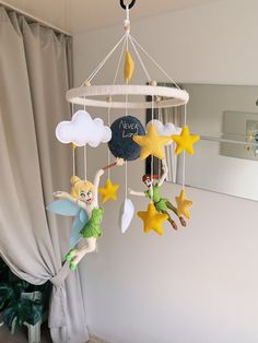 a baby mobile with tinkerbells and stars hanging from it's sides