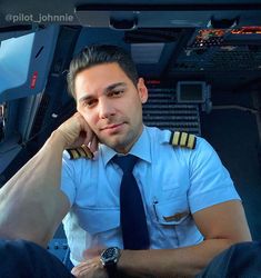 a pilot sitting in the cockpit of an airplane with his hand on his chin and looking at the camera