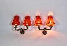 three red lamps are on the wall next to each other