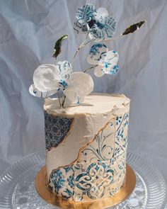 a blue and white cake with flowers on top