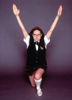 a woman sitting on the ground with her arms in the air