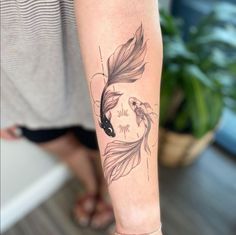 a woman's leg with a tattoo on it that has a fish and leaves