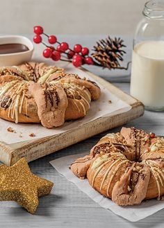 cinnamon bundts with icing on a cutting board next to a glass of milk