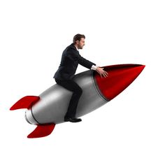 a man in a suit is sitting on a rocket like object with his legs spread out