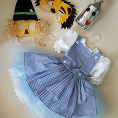 the doll is wearing a blue dress with white trims and has an animal mask on it