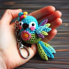 a small crocheted bird keychain is being held by someone's hand