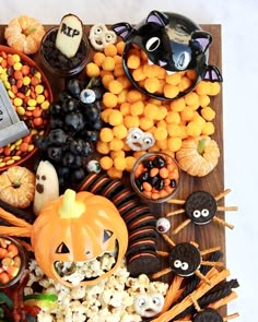 a wooden tray filled with halloween treats and candies