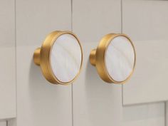 two round mirrors mounted to the side of a white cabinet