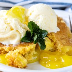 a piece of cake with ice cream and lemon on top is sitting on a white plate