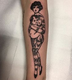 a woman holding a baby tattoo on her arm