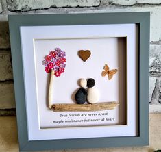 a shadow box frame with two rocks and a tree in the shape of a heart