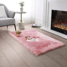 a living room with a pink rug on the floor next to a chair and fire place