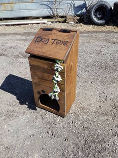 a wooden box with flowers tied to it sitting in the middle of a dirt lot