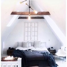 an attic bedroom with white walls and wooden beams