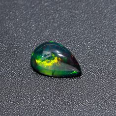 a green and yellow opal sitting on top of a table