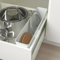 an open drawer with pots and pans in it