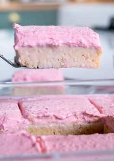 a piece of cake is being held by a fork with pink frosting on it