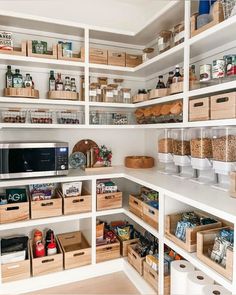 an organized pantry with wooden boxes and baskets