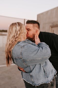 a man and woman kissing in an empty parking lot