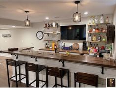 a bar with several stools in front of it and a television mounted on the wall