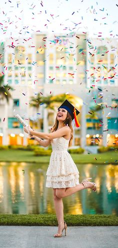 a woman in a graduation cap and gown is throwing confetti into the air