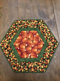 a green and yellow placemat with oranges on it sitting on a wooden table