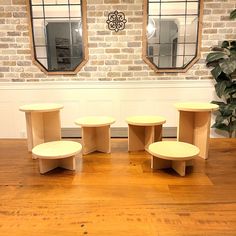 four round tables sitting on top of a hard wood floor next to a potted plant