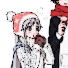 a man and woman in winter clothes eating food