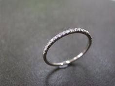 a diamond wedding band on a black surface