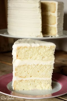 a slice of white cake sitting on top of a plate next to another piece of cake