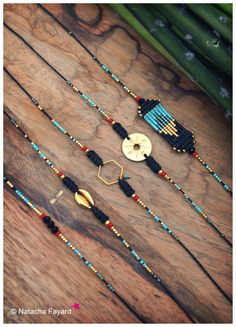 some beads are laying on top of a wooden table next to bamboo sticks and other items