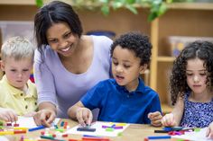 a woman and two children are playing with magnets