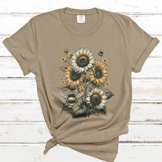 "Embrace the harmony of nature with this enchanting Comfort Colors T-shirt, featuring a lush depiction of sunflowers in bloom, accompanied by the serene buzz of bees in their natural dance. This design captures the essence of a vibrant pollinator garden, bringing to life the symbiotic relationship between these majestic flowers and their vital companions. Rendered on the superior softness of a Comfort Colors T-shirt, known for its cozy feel and vintage look, this piece promises not only style but also exceptional comfort. Each shirt is crafted from 100% cotton, providing breathability and long-lasting wear. The pigment-dye process gives each garment a unique character, destined to become a favorite in any wardrobe. Available in sizes ranging from small to 3XL, this unisex T-shirt offers a Spring Crew Neck T-shirt For Outdoor, Summer Nature-inspired Crew Neck T-shirt, Nature-inspired Crew Neck T-shirt For Summer, The Symbiotic Relationship Between, Bee Sunflower, Pollinator Garden, Comfort Colors Tee, Garden Gifts, Bumble Bee