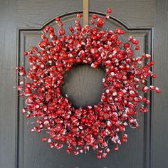 a red berry wreath hangs on the front door