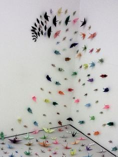 an art installation with many colorful birds on the wall and in the middle of it