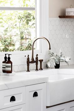 a kitchen sink with two faucets and soap dispensers