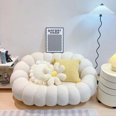 a white couch sitting on top of a wooden floor next to a lamp and table