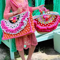 a woman is holding two purses in her hands