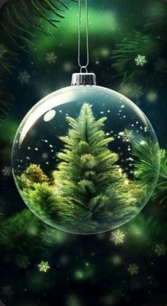 a christmas ornament hanging from a tree with snowflakes on the ground