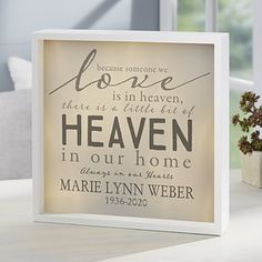 a light box with a quote on it sitting on a table next to a potted plant