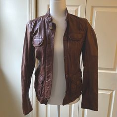 Gap Genuine Leather Jacket. Never Worn! Beautiful Rich Dark Brown Color With Zip And Button Closures. Size Xs. Functional Pockets Approx 16 Inches Shoulder To Shoulder Approx 23 Inches Collar To Bottom Seam Approx 25 Inches Sleeve Length Fitted Brown Biker Jacket With Button Closure, Fitted Leather Jacket With Flap Pockets, Button-up, Casual Fitted Leather Jacket With Button Closure, Casual Fitted Biker Jacket With Buttons, Classic Gap Outerwear With Buttons, Gap Spring Outerwear With Snap Buttons, Gap Long Sleeve Outerwear With Snap Buttons, Long-sleeved Outerwear With Snap Buttons From Gap, Casual Brown Outerwear By Gap