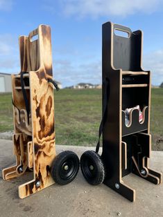 two speakers made out of wood sitting next to each other on the ground in front of a grassy field