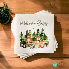 four napkins with woodland animals on them and the words welcome baby written in green ink