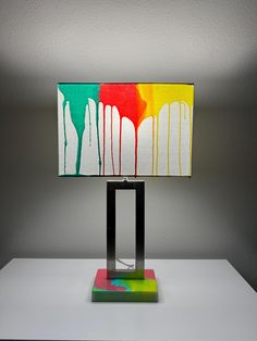 a lamp that is sitting on top of a white table next to a black square