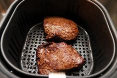 two meat patties being cooked in an air fryer