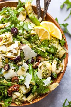 a salad with broccoli, olives and other vegetables in a wooden bowl