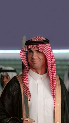 a man dressed in an arabian outfit holding a knife